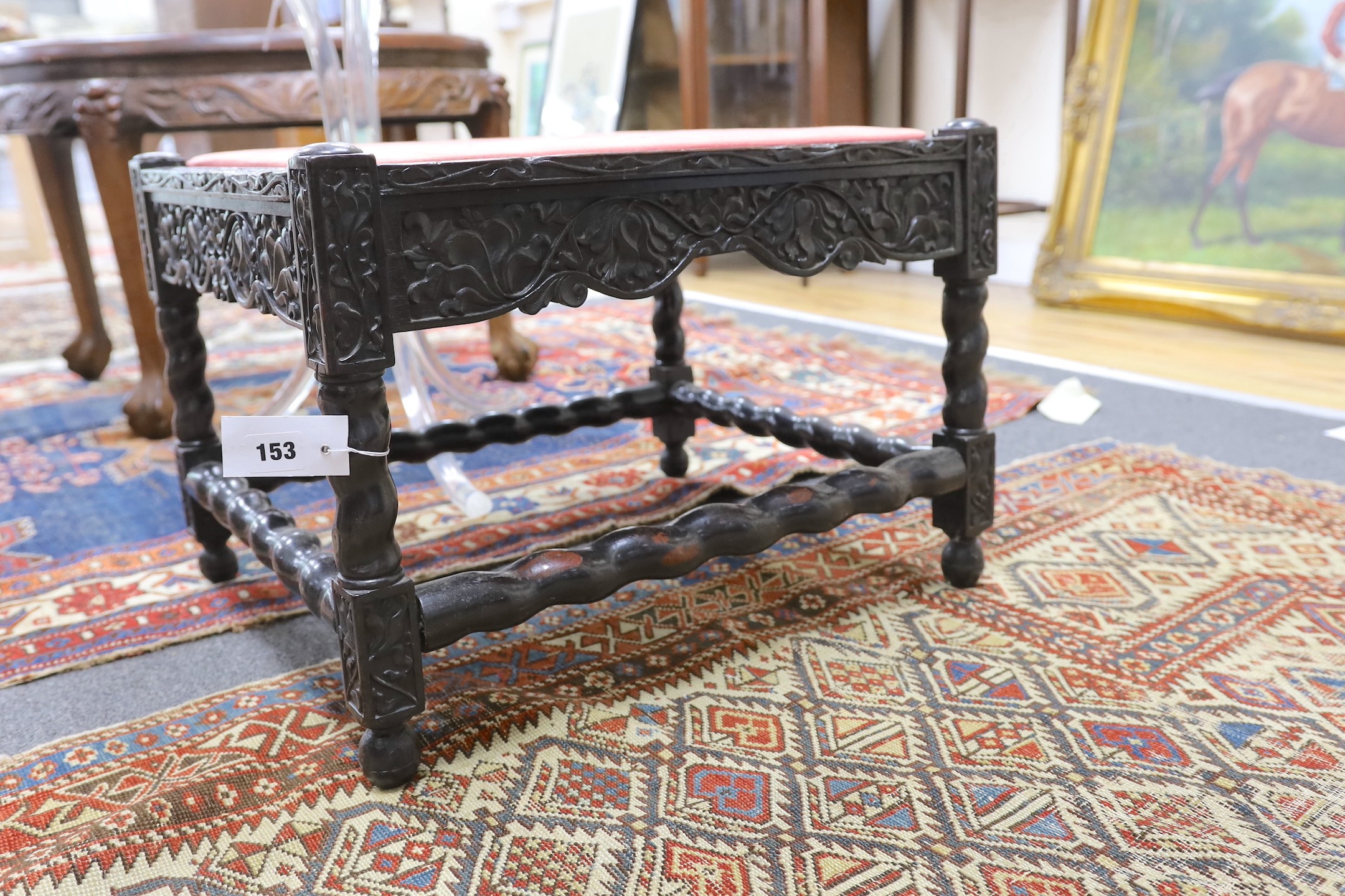 A 19th century Indian carved ebony stool, length 56cm, depth 46cm, height 40cm